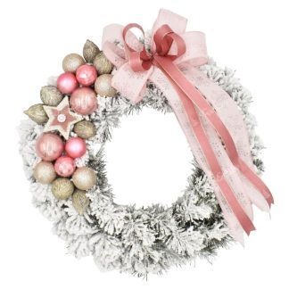 Decorated flocked Christmas wreath on the door in pink color