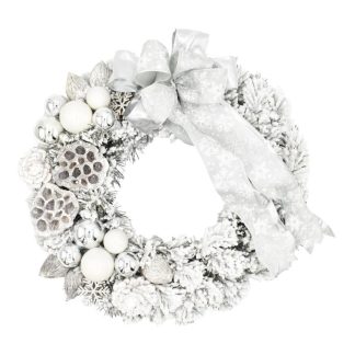 Decorated flocked Christmas wreath on the door in silver-white color