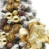 Small decorated flocked Christmas tree in gold color